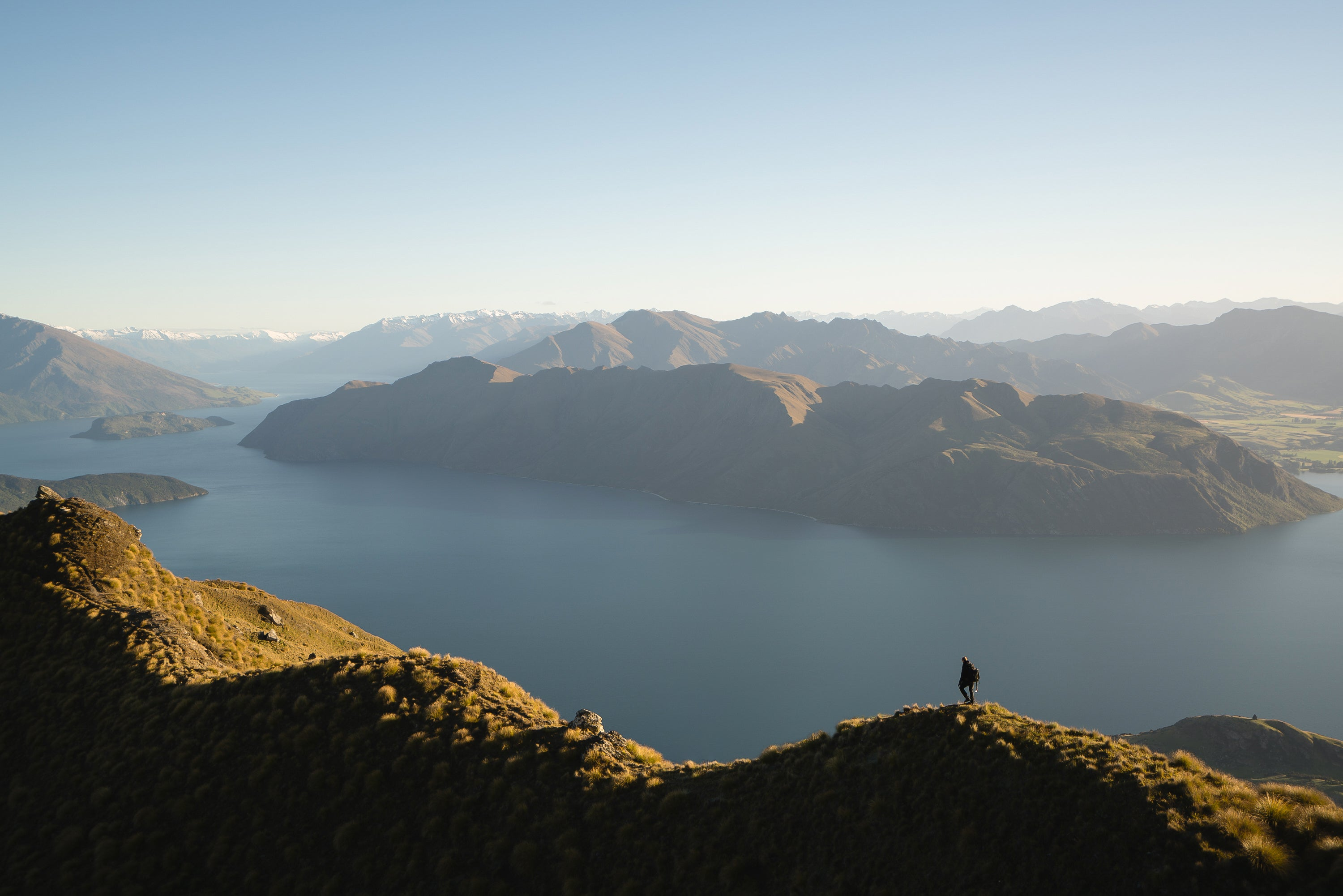 REGEN+ Person standing atop a New Zealand mountain, embracing nature and personal wellness.